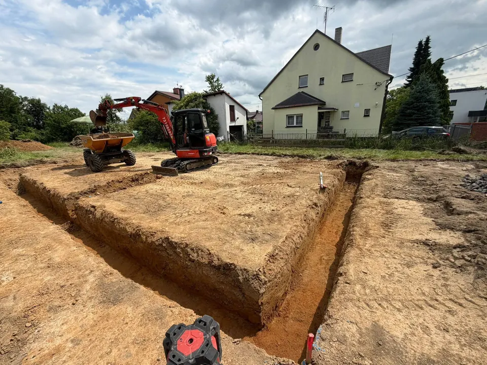 Základové výkopy s bagrem a dumperem v pozadí
