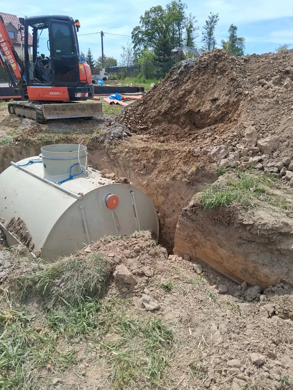Nádrž usazená ve výkopu vedle bagru
