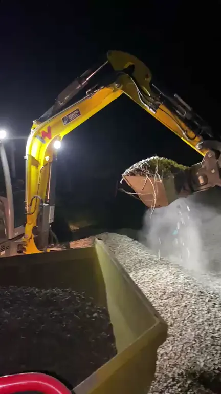 Bagr při večerním nakládání materiálu